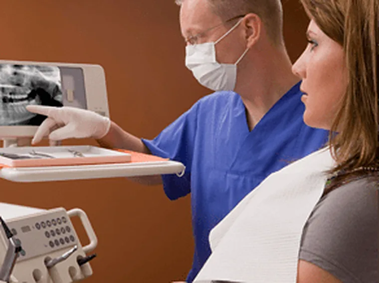 A dentist reading a panoramic scan through with the patient it belongs to.